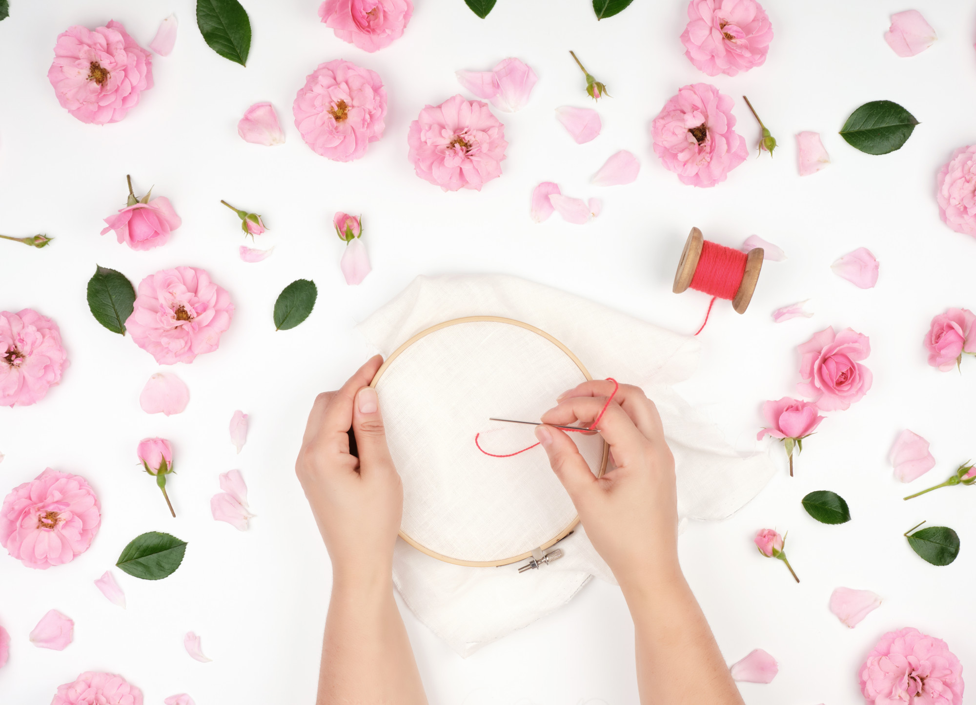 close-up of hands embroidering detailed pattern