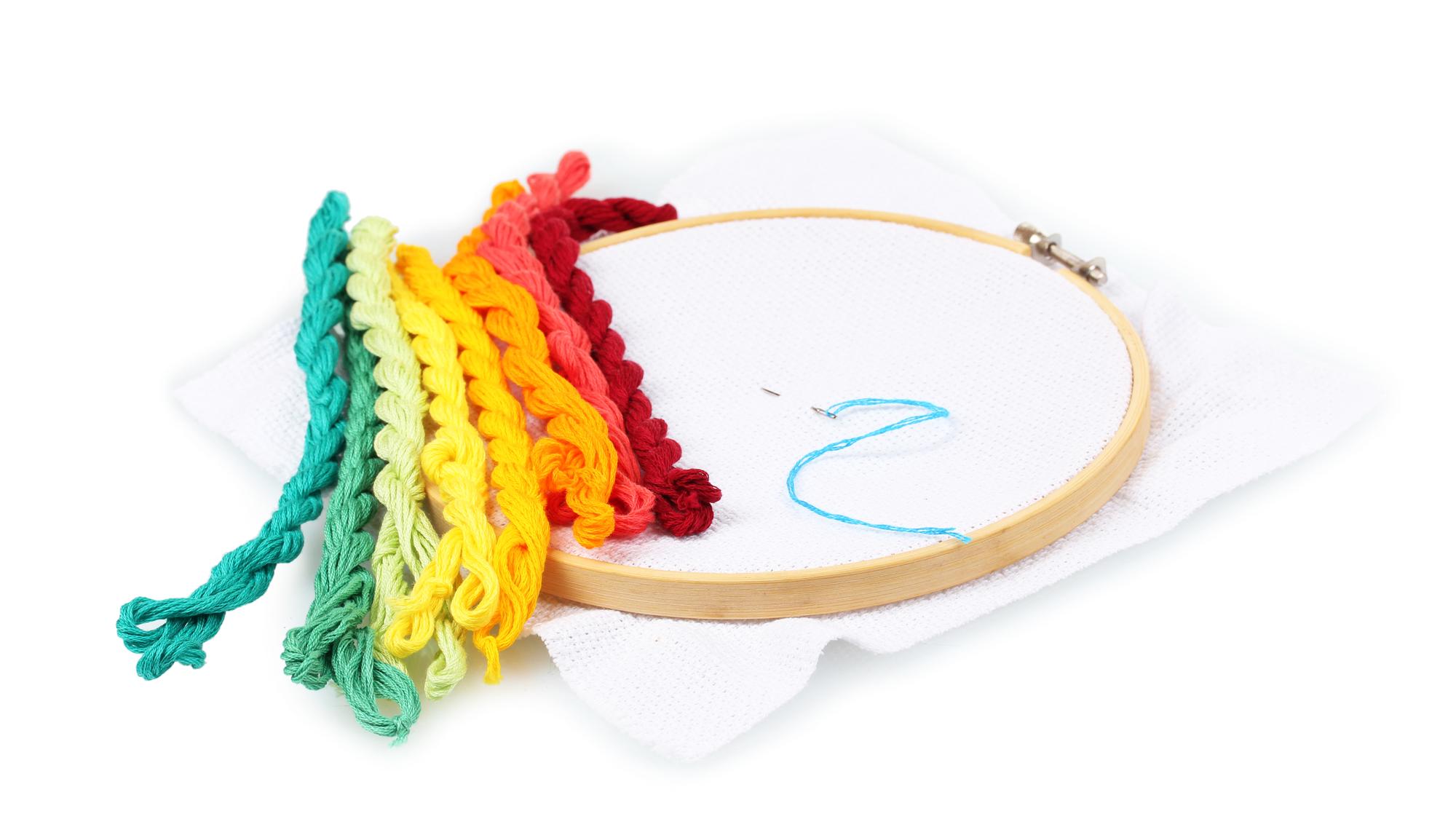teacher demonstrating embroidery technique on hoop